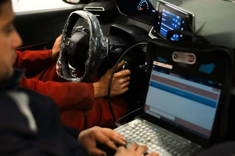 Auton diagnostiikka tietokoneella korjaamon sisällä